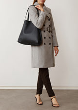 A studio style photo of the buttery soft Australian made Black Nappa Bespoke Tote from Charlie Middleton on a model.
