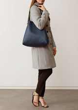 A studio style photo of the buttery soft Australian made Navy Nappa Bespoke Tote from Charlie Middleton on a model.